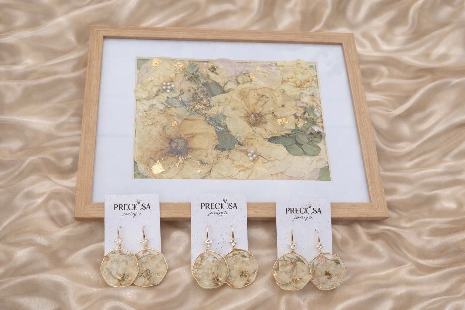 Set of floral earrings with a matching card on a beige fabric background